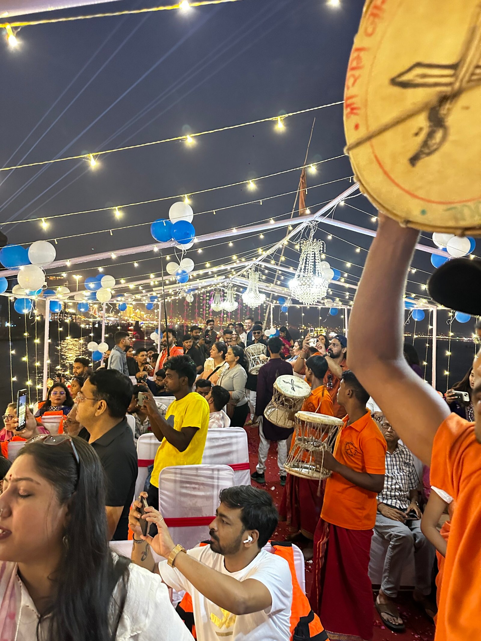 Damru musicians and seated guests aboard a decorated boat during Dev Deepawali 2025 in Varanasi
