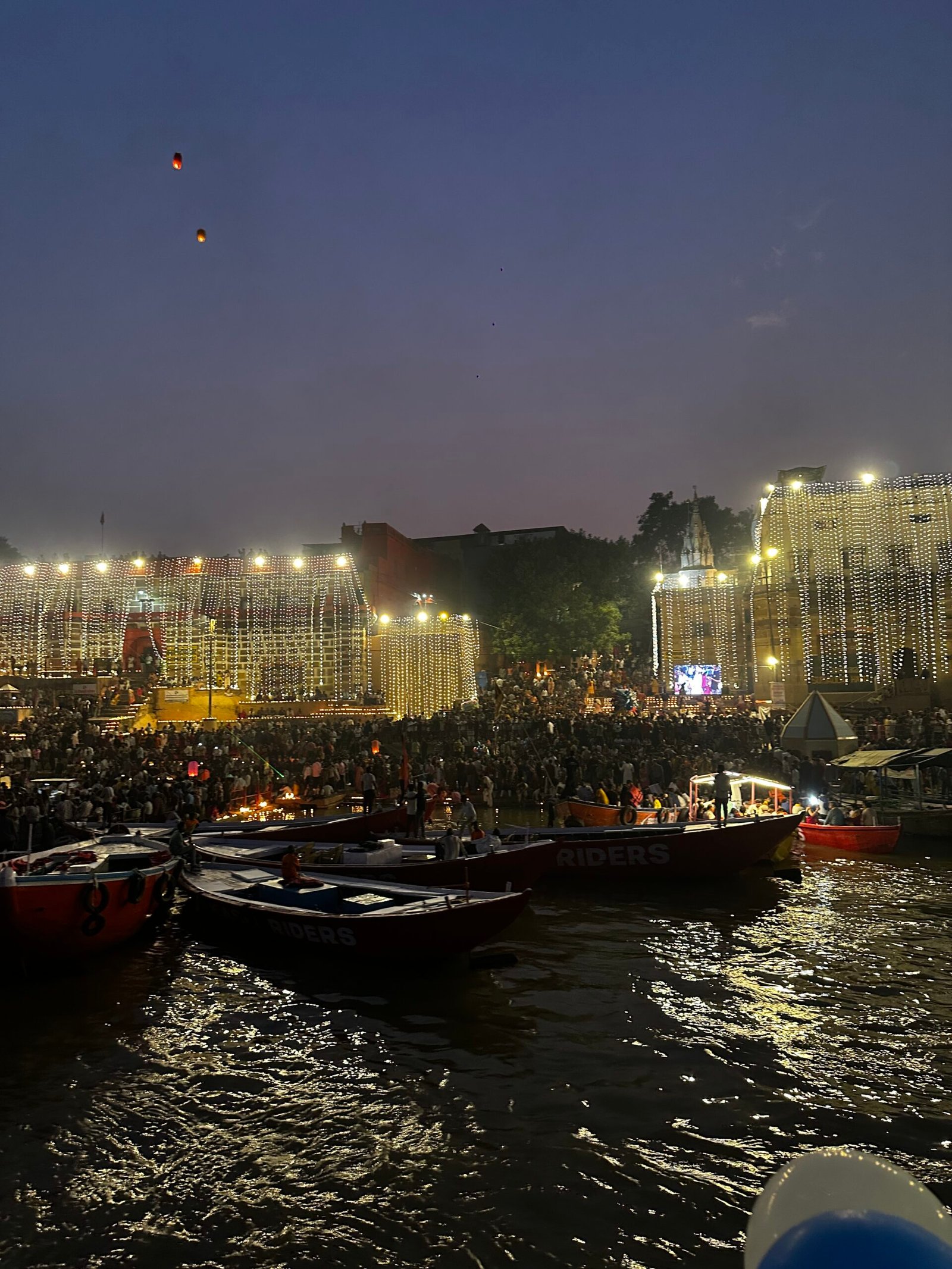 Boats beside illuminated Varanasi ghats during Dev Deepawali 2025