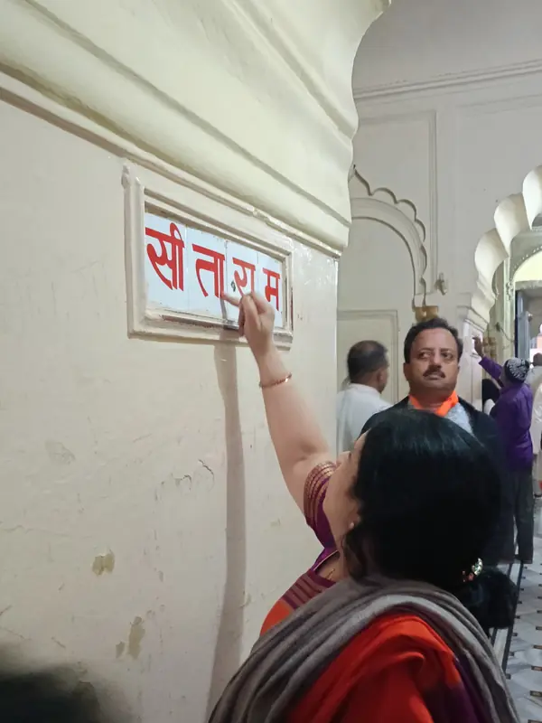 Devotee touching a Sita Ram tile in reverence during a pilgrimage to Ayodhya