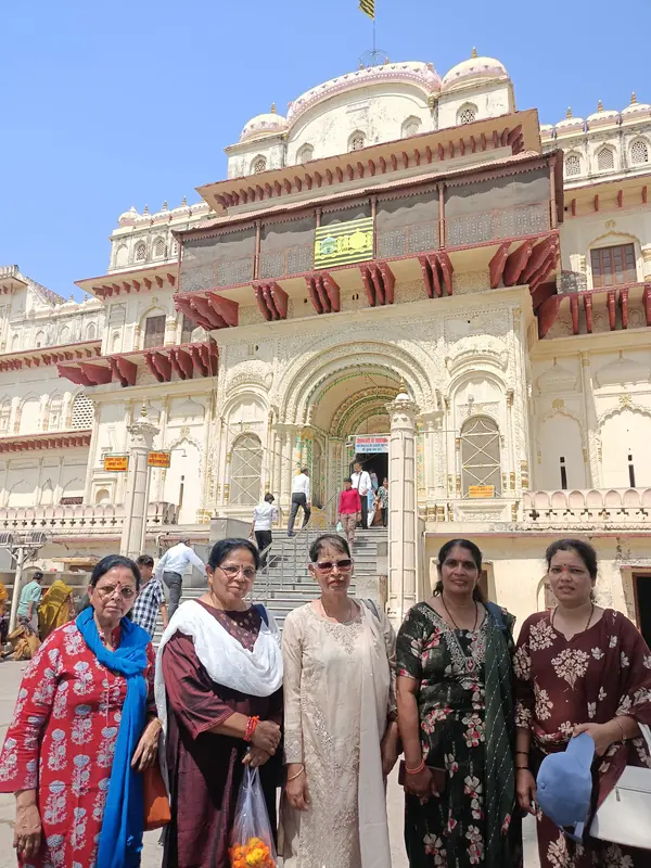 Group of women pilgrims at an ornate temple gate during a House of Ullassa tour of Ayodhya