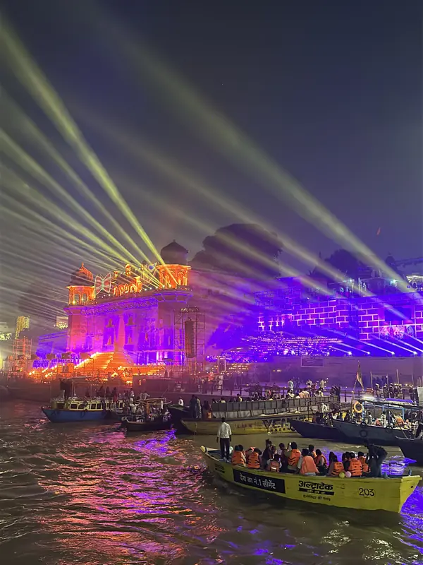 Pilgrims on a yellow boat watch the laser show at a Varanasi ghat