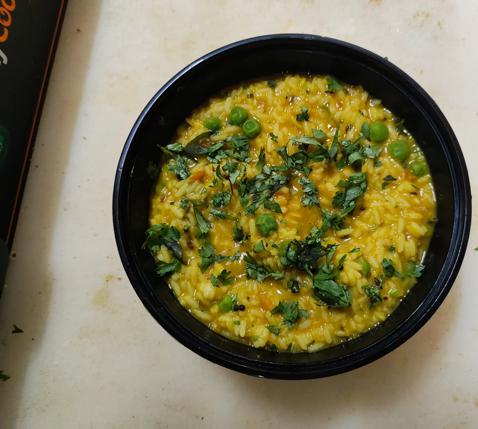Bowl of dal khichadi with green peas, warm late night food at a pure veg cafe near Vagator